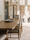 French farmhouse style dining table with solid pine legs and a solid bleached oak tabletop. Tapered, plank-style legs are finished in honey while angled joinery blocks add a unique touch. Seats eight comfortably.